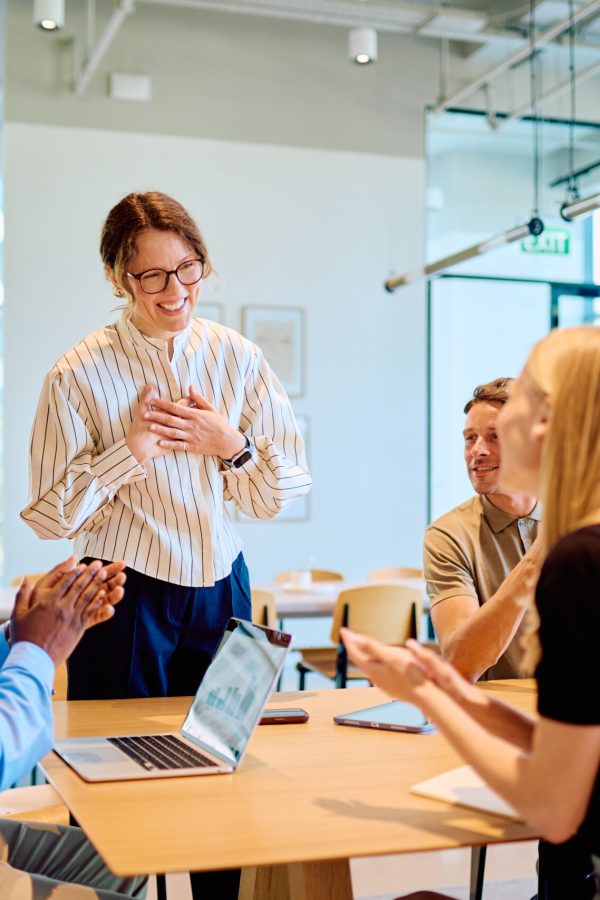 Colleagues applauding team member receiving recognition